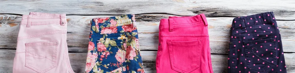 Row of pants folded on wooden background
